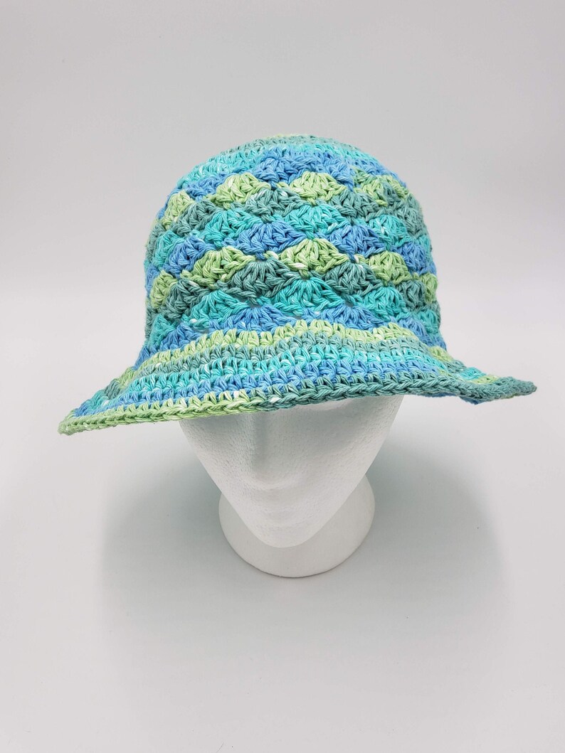 May include: A crocheted sun hat with a wide brim in shades of blue and green.