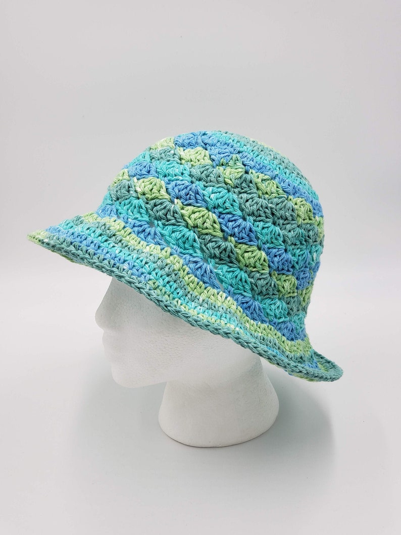 May include: A crocheted sun hat with a wide brim in shades of blue and green.