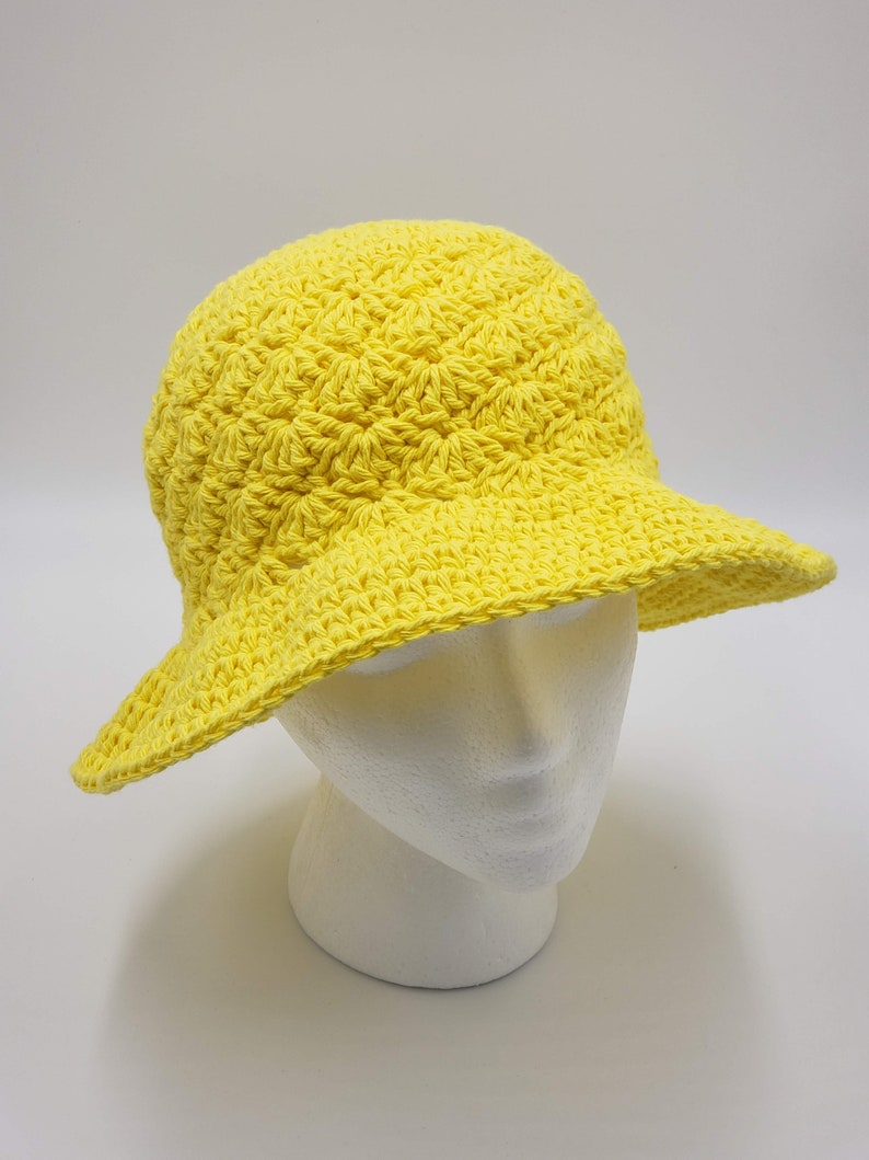 May include: A bright yellow crocheted sun hat with a wide brim.