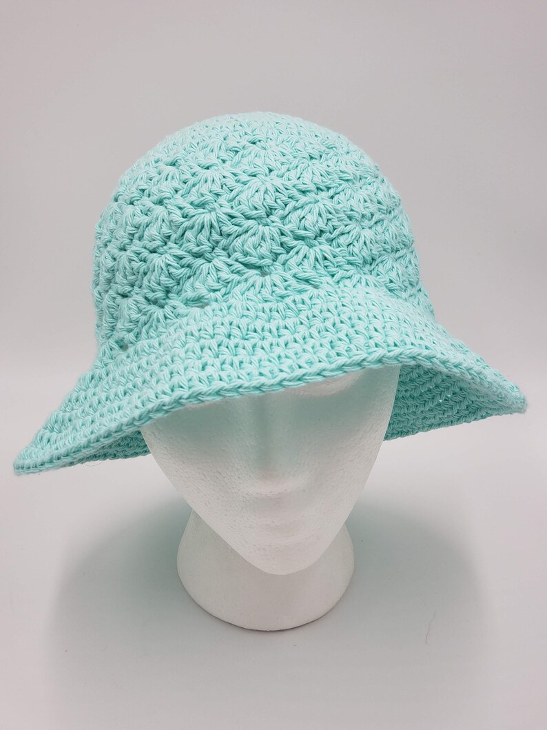 May include: A light blue crocheted sun hat with a wide brim.
