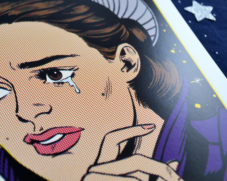 May include: A close-up of a woman's face in a comic book style. She has dark hair and is wearing a purple and black outfit. Her eye is tearful and her mouth is slightly open. The background is a yellow and black pattern.