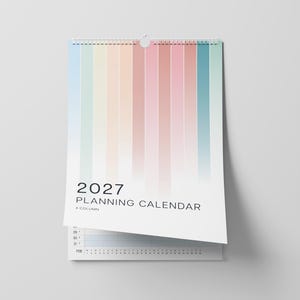 May include: A 2027 wall-mounted planning calendar with a white spiral binding at the top. The cover features vertical stripes in a gradient of pastel colours including blue, yellow, peach, pink, and teal. The text reads 2027 PLANNING CALENDAR 4 COLUMN.