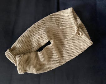 Puede incluir: Un pantalón de punto de ganchillo beige con cintura de cordón.
