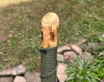 A 46.6” Hazel Hiking Stick with a spiral paracord hand grip & wriststrap , a smooth angled thumb rest and a stout straight and strong shaft