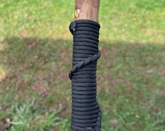 This 44” Holly Hiking Stick: it has a black paracord hand grip, a smooth domed thumb rest and a rustic straight strong shaft