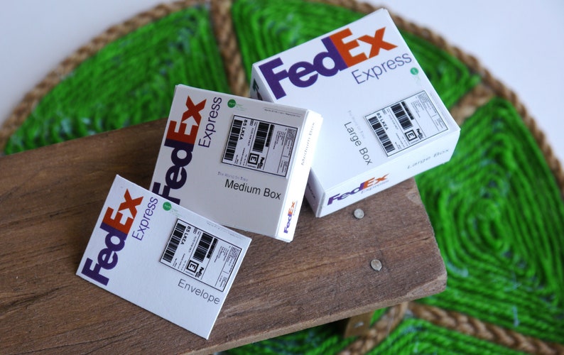以下が含まれることがあります： 異なるサイズの白い FedEx Express ボックスが 3 つあります。最も小さいボックスには「封筒」とラベルが貼られ、中くらいのボックスには「中箱」とラベルが貼られ、最も大きいボックスには「大箱」とラベルが貼られています。