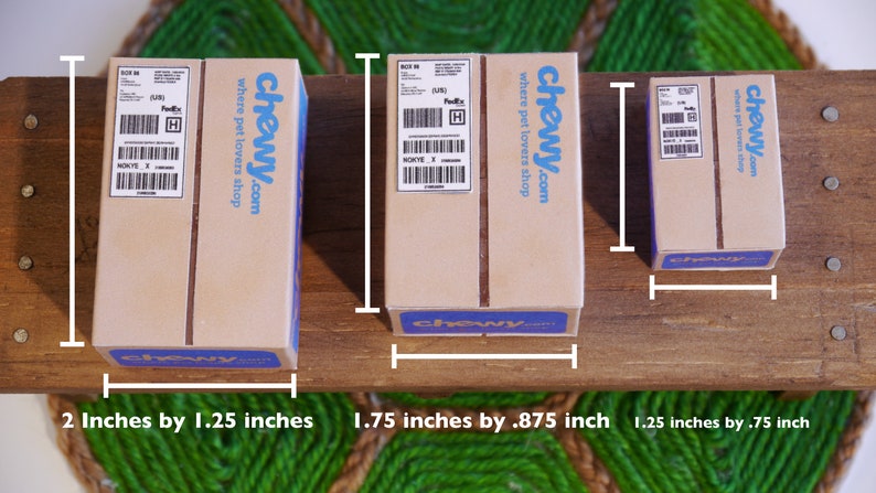 May include: Three cardboard boxes of different sizes with the "chewy.com where pet lovers shop" logo printed on them. The boxes measure 2 inches by 1.25 inches, 1.75 inches by .875 inch, and 1.25 inches by .75 inch.