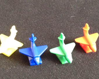 Four Stylized Plastic Game Markers of Jet Planes from a Board Game