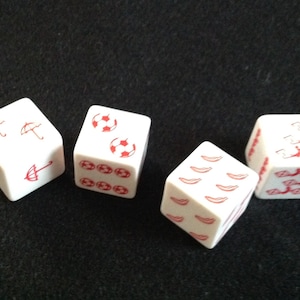 May include: Four white dice with red symbols. The dice show an umbrella, a soccer ball, a chili pepper, and a horseshoe.