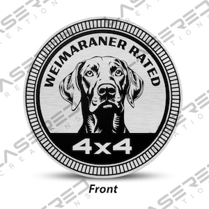 May include: A round, silver-colored emblem featuring a detailed black and white illustration of a Weimaraner dog. The text "WEIMARANER RATED" and "4x4" are displayed in black. The word "Front" is at the bottom.