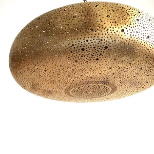 Moroccan Brass Lantern Chandelier with Stunning Light Pattern
Bring the magic of Marrakesh into your home with this magnificent, handcrafted Moroccan Brass Pendant Light. Known for its exquisite craftsmanship, this lamp is meticulously hand-punched, allowing light to filter through a myriad of small perforations to cast an immersive, spectacular, starburst pattern of light and shadow on your walls and ceiling.
