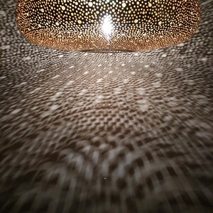 Moroccan Brass Lantern Chandelier with Stunning Light Pattern
Bring the magic of Marrakesh into your home with this magnificent, handcrafted Moroccan Brass Pendant Light. Known for its exquisite craftsmanship, this lamp is meticulously hand-punched, allowing light to filter through a myriad of small perforations to cast an immersive, spectacular, starburst pattern of light and shadow on your walls and ceiling.