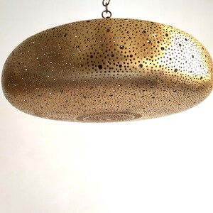 Moroccan Brass Lantern Chandelier with Stunning Light Pattern
Bring the magic of Marrakesh into your home with this magnificent, handcrafted Moroccan Brass Pendant Light. Known for its exquisite craftsmanship, this lamp is meticulously hand-punched, allowing light to filter through a myriad of small perforations to cast an immersive, spectacular, starburst pattern of light and shadow on your walls and ceiling.