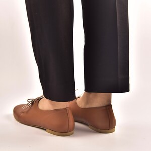 Puede incluir: Zapatos marrones de cuero con cordones y tac&oacute;n bajo.