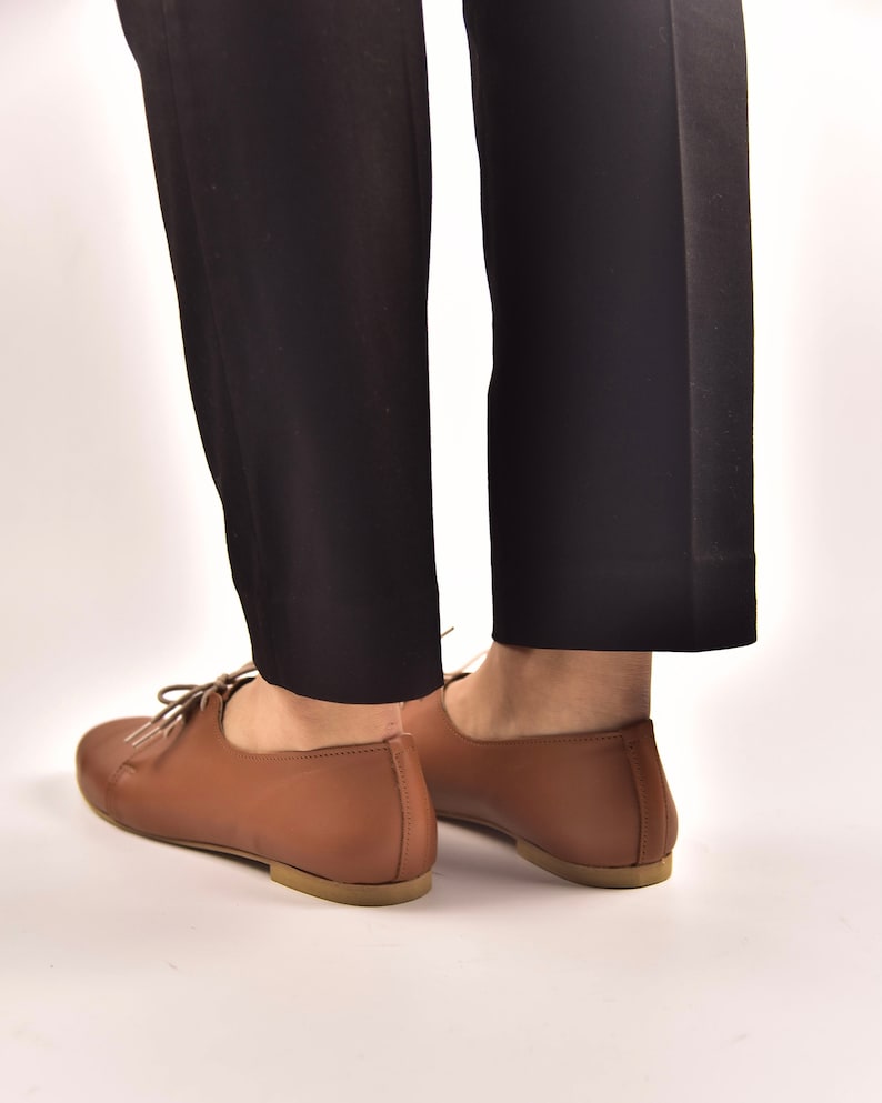Puede incluir: Zapatos marrones de cuero con cordones y tac&oacute;n bajo.