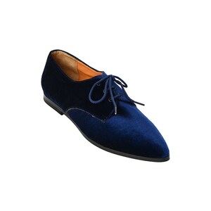May include: Navy blue velvet lace-up flat shoes with a pointed toe.