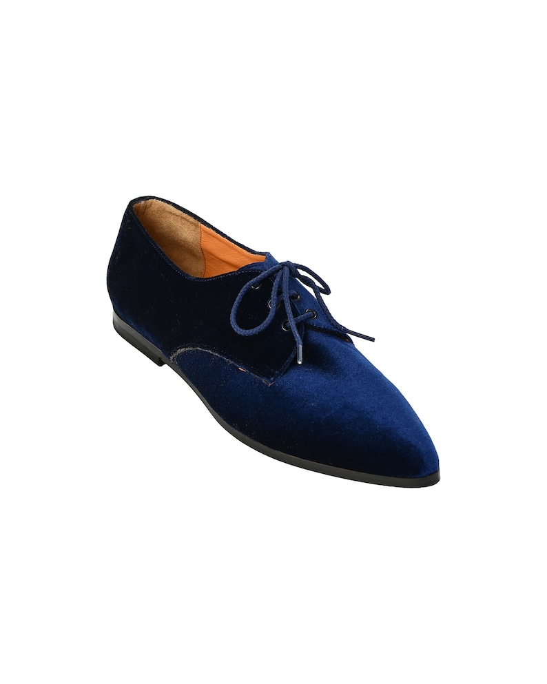 May include: Navy blue velvet lace-up flat shoes with a pointed toe.