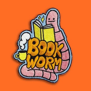 Könnte beinhalten: Gestickter Aufnäher mit einem Cartoon-Bücherwurm, der ein Buch liest. Das Design umfasst einen rosa Wurm, ein gelbes Buch, eine Tasse Kaffee und die Worte "BOOK WORM" in Orange. Der Aufnäher hat einen hellblauen Rand und ist vor einem orangefarbenen Hintergrund platziert.