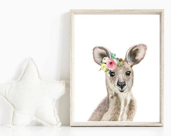 May include: A watercolor painting of a kangaroo with a floral crown. The kangaroo is light brown with a pink nose and a white background.