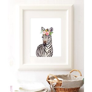 K&ouml;nnte beinhalten: Ein Aquarellbild eines Zebras mit einer Blumenkrone. Das Zebra ist schwarz-wei&szlig; mit einer rosa Nase und einer rosa Blumenkrone. Der Hintergrund ist wei&szlig;.