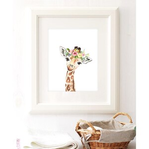 K&ouml;nnte beinhalten: Ein Aquarellbild einer Giraffe mit einer Blumenkrone. Die Giraffe schaut den Betrachter mit einem s&uuml;&szlig;en Ausdruck an. Der Hintergrund ist wei&szlig;.