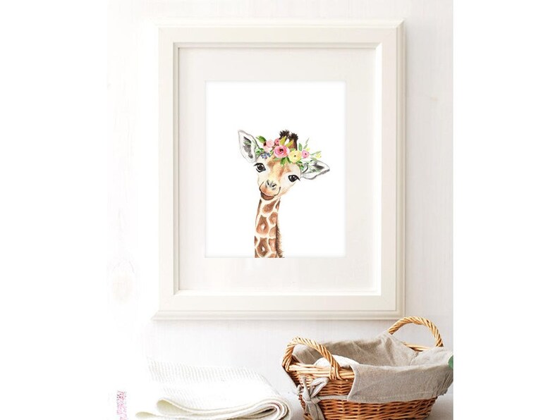 K&ouml;nnte beinhalten: Ein Aquarellbild einer Giraffe mit einer Blumenkrone. Die Giraffe schaut den Betrachter mit einem s&uuml;&szlig;en Ausdruck an. Der Hintergrund ist wei&szlig;.