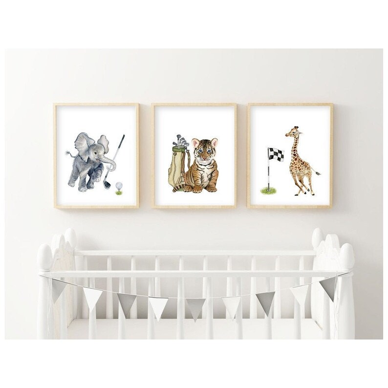May include: Three watercolor paintings of animals playing golf. A grey elephant swings a golf club, a tiger holds a golf bag, and a giraffe stands by a golf flag.