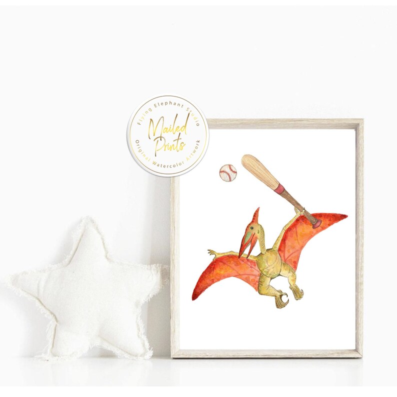 Op de afbeelding: Een aquarel illustratie van een pterodactylus die honkbal speelt. De pterodactylus vliegt in de lucht met een honkbalknuppel in zijn hand en een honkbal in de lucht. De illustratie is op een witte achtergrond.