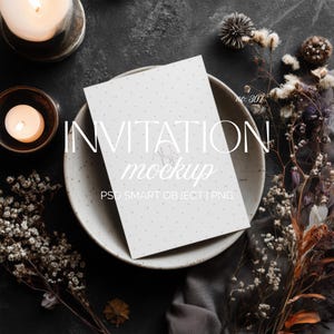 May include: An invitation mockup with the text "INVITATION mockup" on a white card with small gray polka dots, resting in a light gray ceramic bowl. The scene includes lit candles, dried flowers, and a dark gray background.