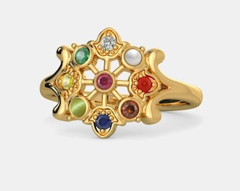 May include: A gold ring with a decorative design featuring a wheel with nine gemstones: a white pearl, a red ruby, a green emerald, a blue sapphire, a yellow citrine, a brown topaz, a green peridot, a red carnelian, and a clear diamond.