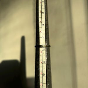 K&ouml;nnte beinhalten: Ein Metall-Ringma&szlig; mit Markierungen von Gr&ouml;&szlig;e 13 bis 22. Der Ringma&szlig; wird verwendet, um die richtige Ringgr&ouml;&szlig;e zu bestimmen.