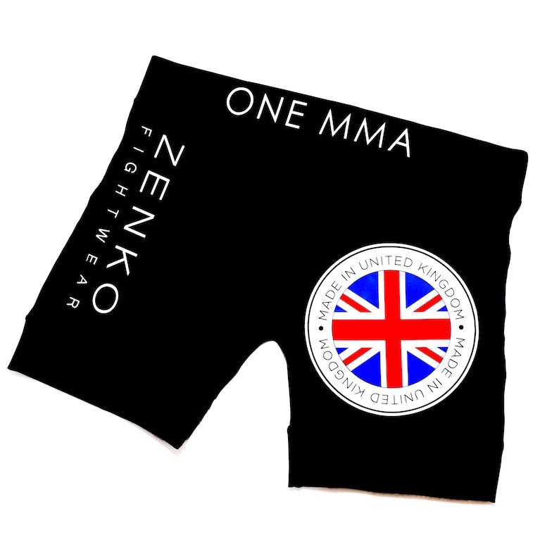 May include: Black athletic shorts with the text "ONE MMA" and "ZENKO FIGHTWEAR" printed in white. The shorts also feature a white circle with a red, white, and blue Union Jack flag and the text "MADE IN UNITED KINGDOM" printed around the circle.