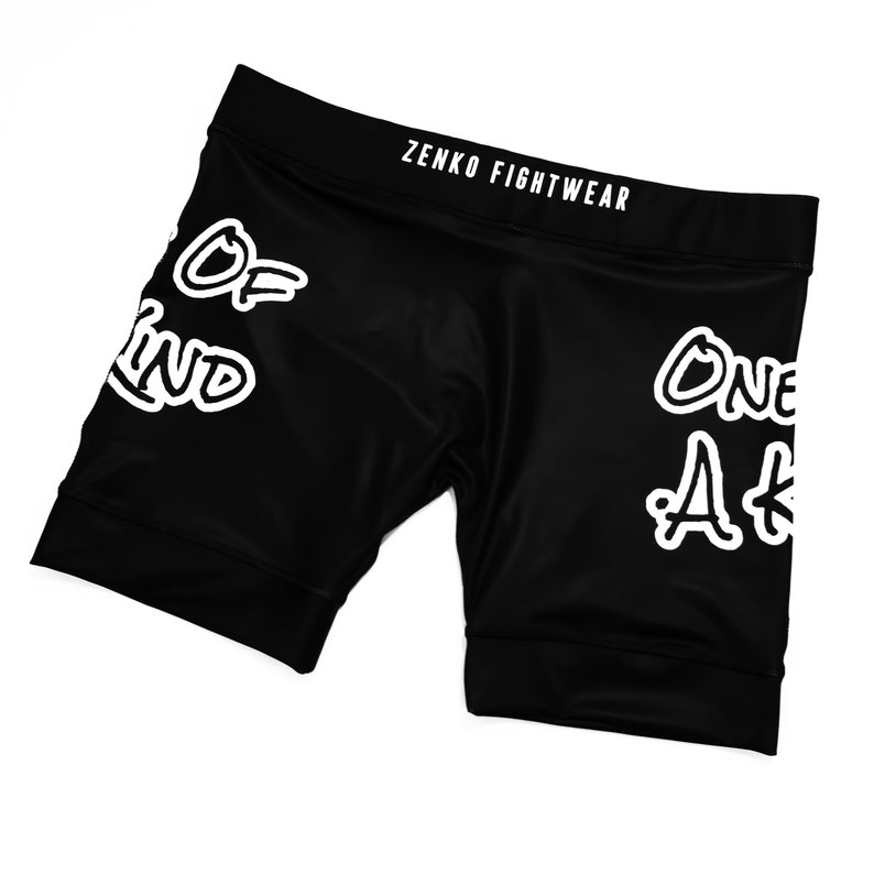 May include: Black athletic shorts with white text that says "One of a Kind" and "Zenko Fightwear".