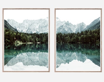 May include: A split-panel print featuring a scenic view of a lake reflecting snow-capped mountains and a forest. The image is framed in a light wood frame.