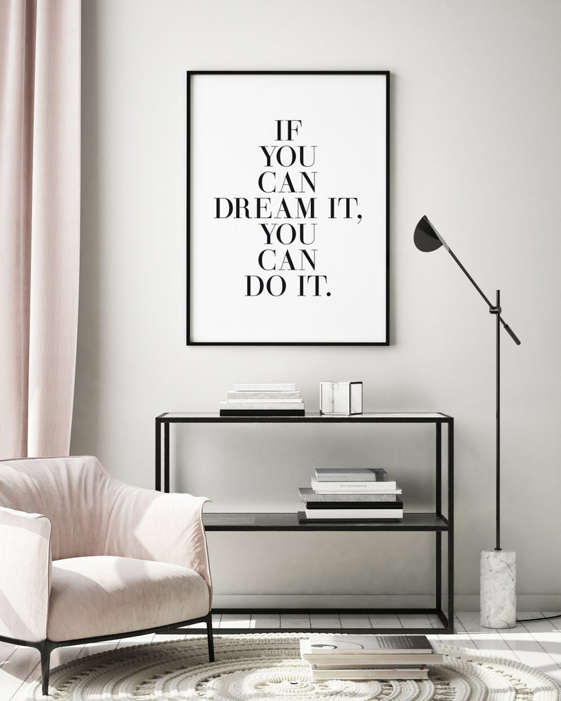 May include: Black and white motivational quote print in a black frame, hanging on a white wall. The quote reads "If you can dream it, you can do it."