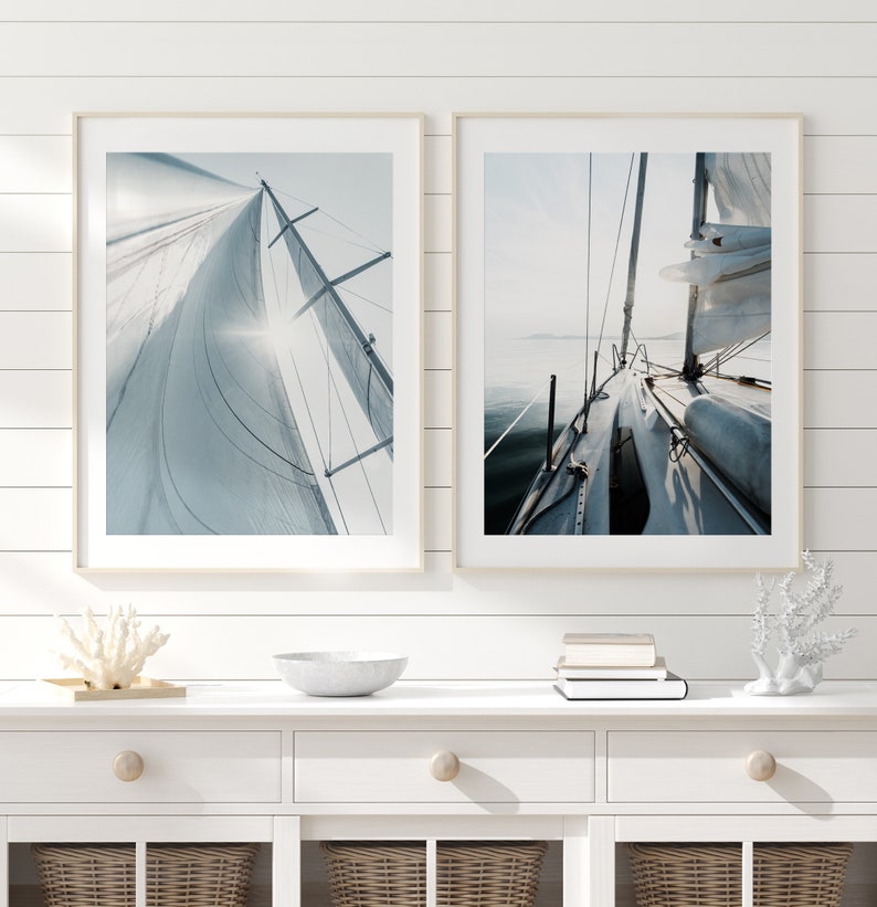 May include: Two framed photographs of a sailboat on the water. The first photo shows the sail billowing in the wind. The second photo shows the deck of the boat.