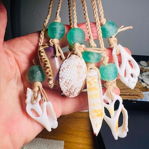 May include: Five necklaces with various seashells and green glass beads. The necklaces are made with natural twine and have a rustic look.