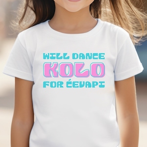 May include: White t-shirt with a blue and pink graphic that says "Will Dance Kolo for Ćevapčići".