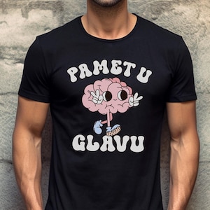 May include: Black t-shirt with a white graphic of a cartoon brain wearing shoes and making peace signs. The text "PAMETU GLAVU" is written in white letters.