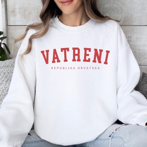 Pu&ograve; includere: Felpa bianca con testo rosso che recita "VATRENI REPUBLIKA HRVATSKA".