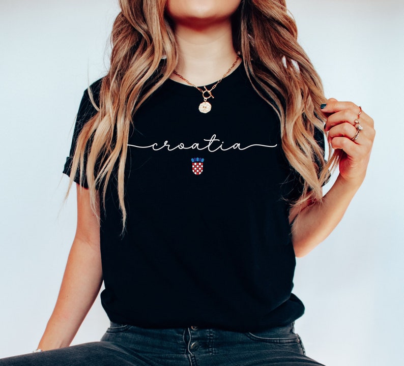 May include: Black t-shirt with the word "croatia" written in white script with a Croatian flag emblem underneath.