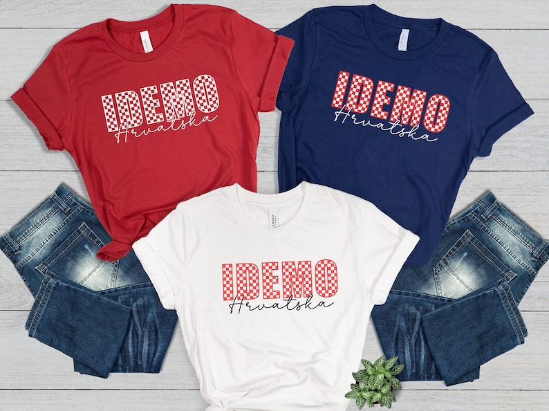 May include: Three t-shirts with the text "IDEMO Hrvatska" in a checkered pattern. The shirts are red, white, and navy blue. The text is in white and the checkered pattern is red and white.