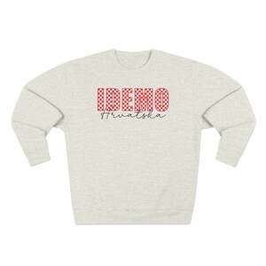 May include: A light gray sweatshirt with a red and white checkered design that says "IDEMO" and "Hrvatska" in black lettering.
