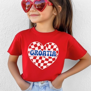 May include: Red t-shirt with a white and red checkered heart design and the word "CROATIA" in blue letters.