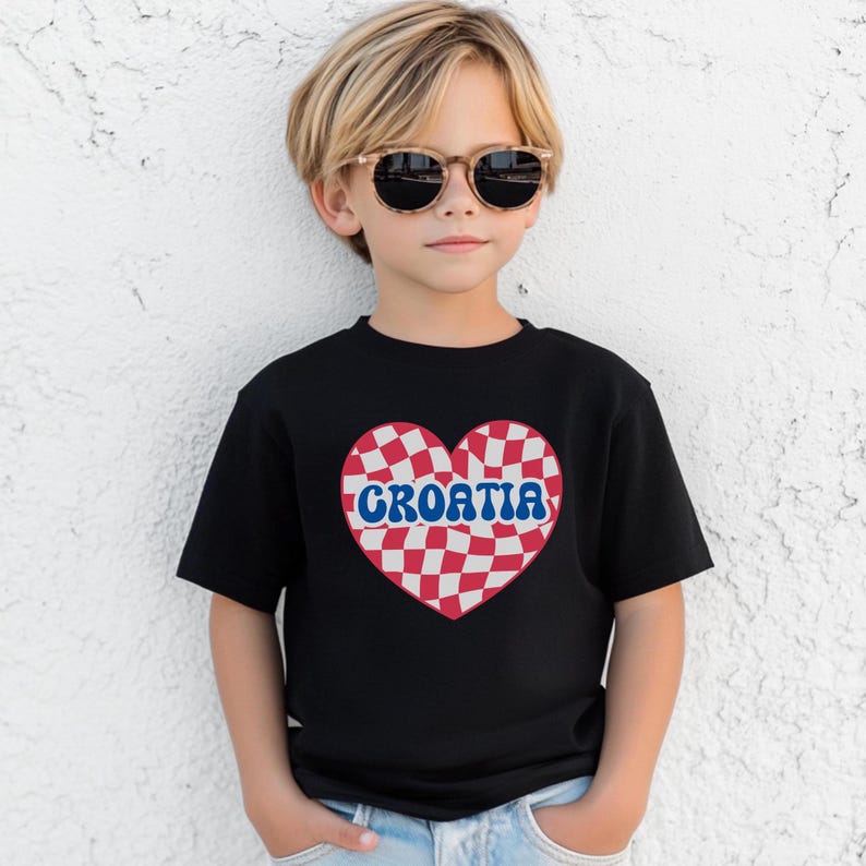 May include: A black t-shirt with a red and white checkered heart design. The heart has the word "CROATIA" written in blue letters across it.