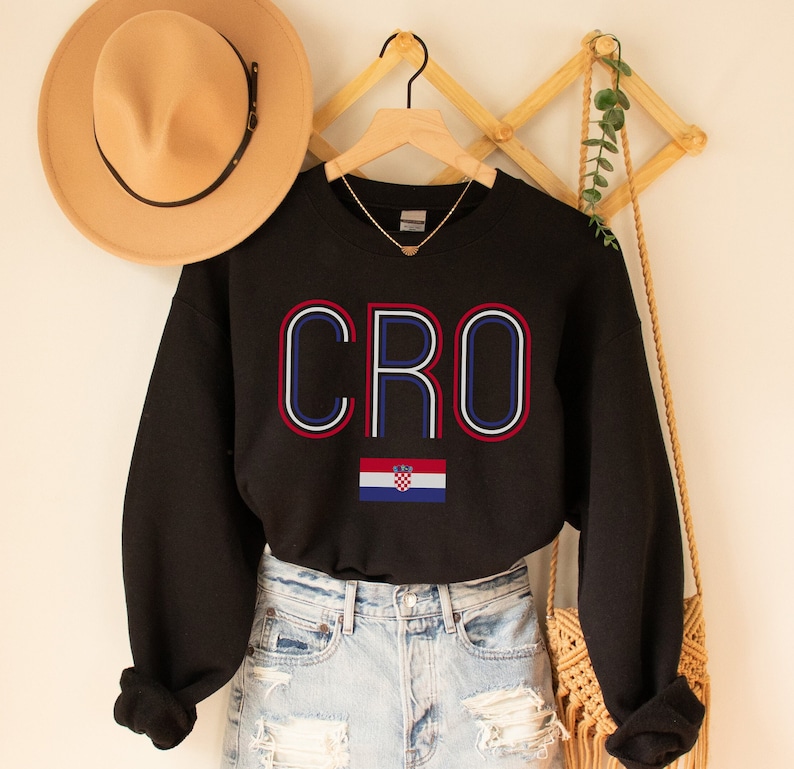 May include: Black sweatshirt with the word "CRO" in red, white and blue outlined letters. The Croatian flag is below the word.