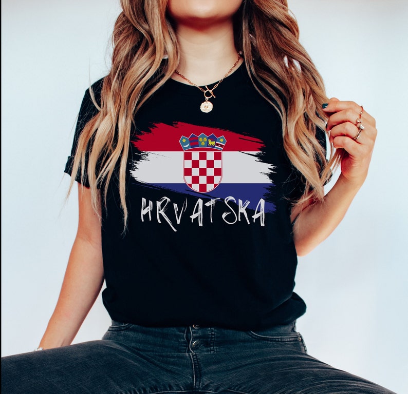 May include: Black t-shirt featuring a white paint-splattered Croatian flag and the word "HRVATSKA" in white lettering.