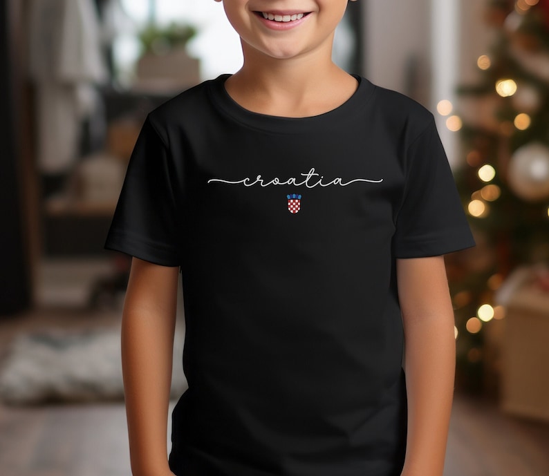 May include: A black t-shirt with the word "croatia" written in white cursive script. A small Croatian flag is centered below the word.