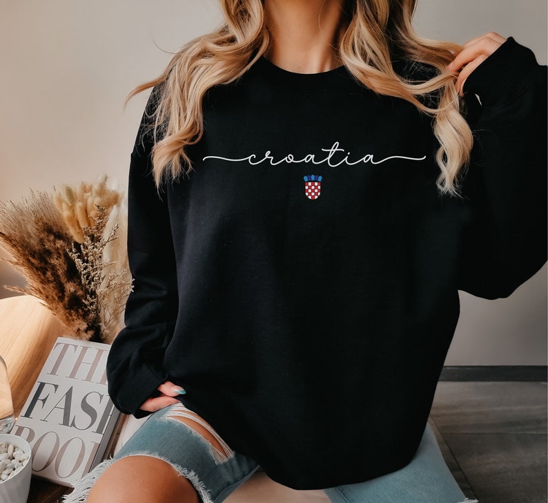 May include: Black sweatshirt with the word "croatia" written in white cursive script and a small Croatian flag embroidered on the front.
