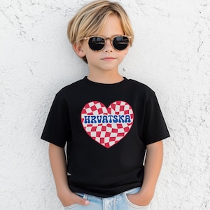 Puede incluir: Una camiseta negra con un dise&ntilde;o de coraz&oacute;n a cuadros rojos y blancos. El coraz&oacute;n tiene la palabra "HRVATSKA" escrita en letras azules.